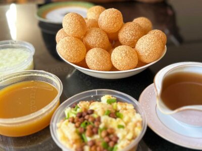 Components of panipuri: puti (fried hollow flatbread), potato mash, tamarind chutney, curd and spiced water